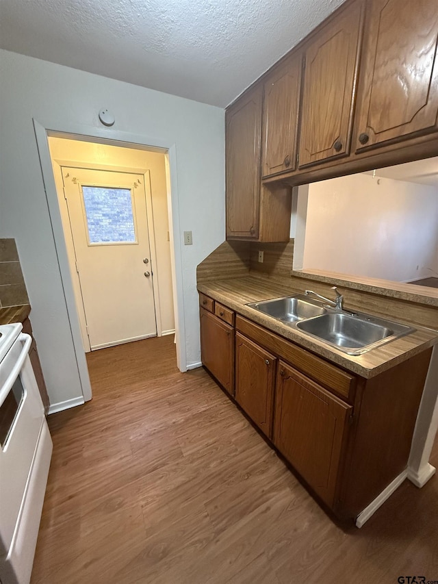 kitchen with dark wood-type flooring, sink, a textured ceiling, and white electric range