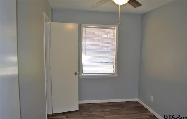 unfurnished room featuring plenty of natural light, ceiling fan, and dark hardwood / wood-style flooring