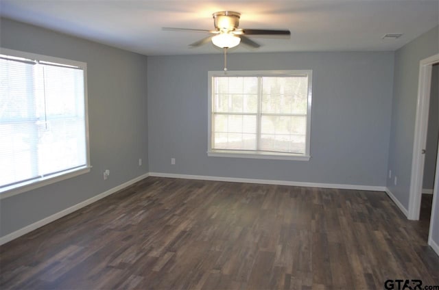 empty room with dark hardwood / wood-style floors and a healthy amount of sunlight