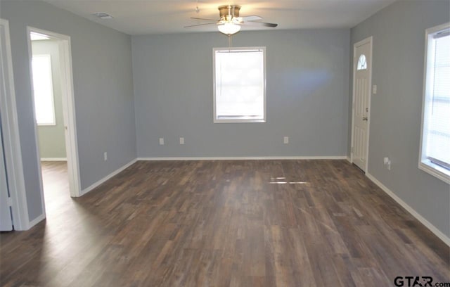 unfurnished room featuring a wealth of natural light, ceiling fan, and dark wood-type flooring