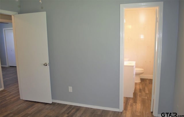 unfurnished bedroom featuring dark hardwood / wood-style floors and ensuite bathroom