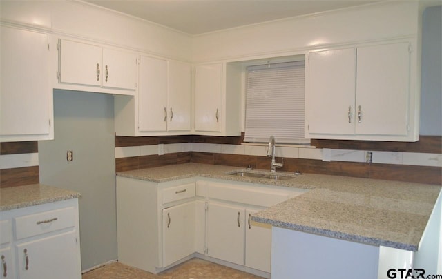 kitchen featuring white cabinets, ornamental molding, and sink