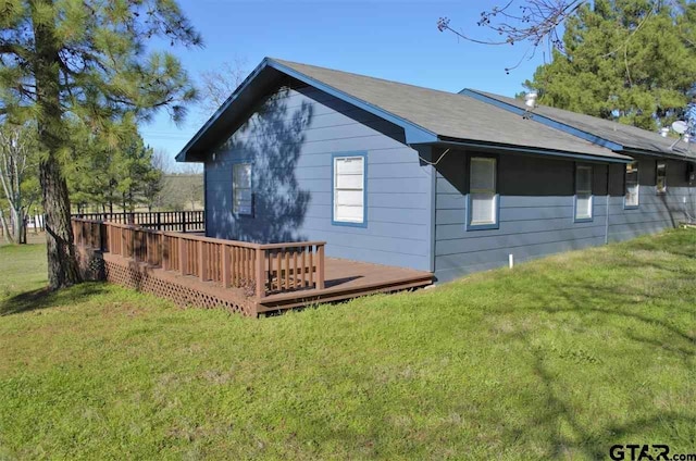 rear view of property featuring a lawn and a wooden deck