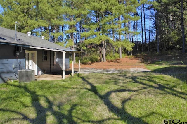 view of yard with central air condition unit and french doors