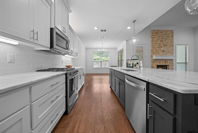 4132 Palo Pinto Creek Cir, Tyler, TX 75703 - kitchen featuring appliances with stainless steel finishes, a sink, white cabinetry, backsplash, and dark wood finished floors