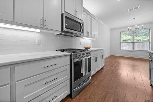 4132 Palo Pinto Creek Cir, Tyler, TX 75703 - kitchen featuring appliances with stainless steel finishes, a chandelier, baseboards, decorative backsplash, and dark wood-type flooring
