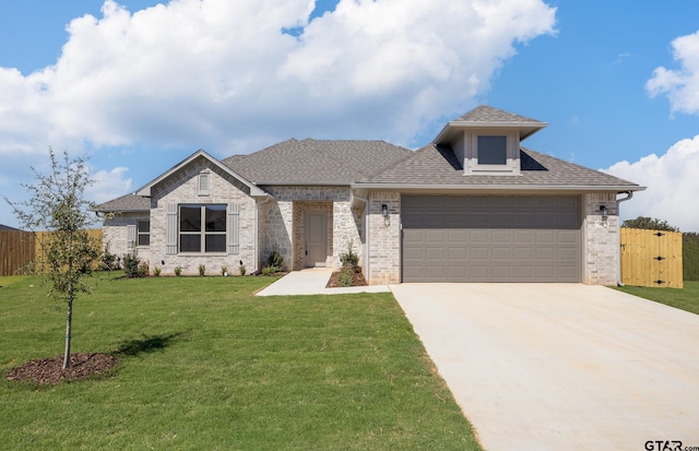 view of front of house featuring a garage and a front lawn