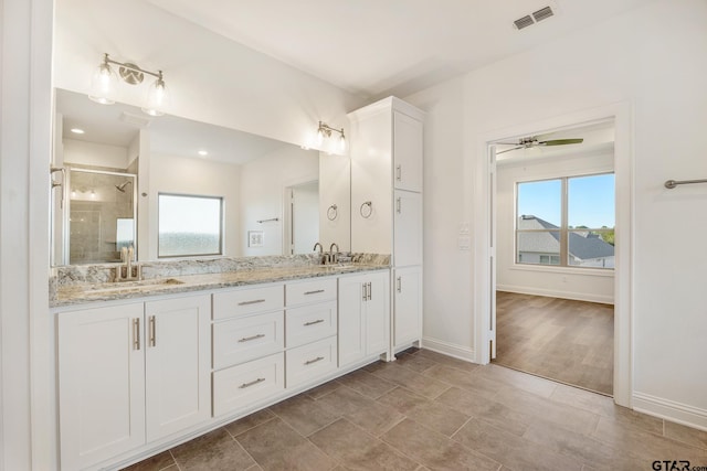 bathroom featuring hardwood / wood-style floors, ceiling fan, an enclosed shower, and vanity