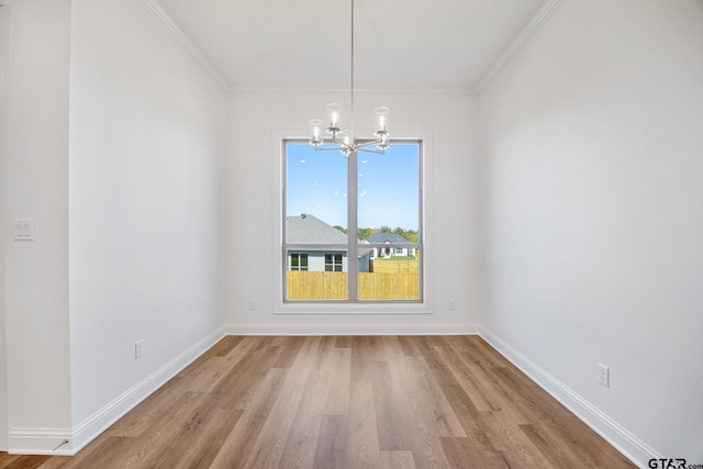 unfurnished dining area featuring an inviting chandelier, light hardwood / wood-style flooring, and ornamental molding