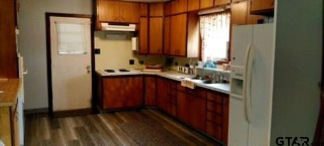 307 Lowry St, Arp, TX 75750 - kitchen with white fridge with ice dispenser, brown cabinets, light countertops, dark wood-style floors, and under cabinet range hood