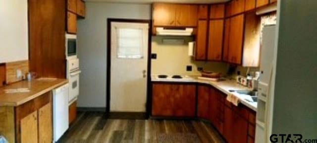 307 Lowry St, Arp, TX 75750 - kitchen featuring brown cabinets, light countertops, under cabinet range hood, and dark wood finished floors