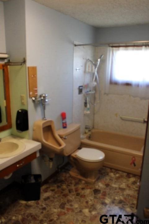 307 Lowry St, Arp, TX 75750 - bathroom featuring toilet, shower / tub combination, vanity, and a textured ceiling
