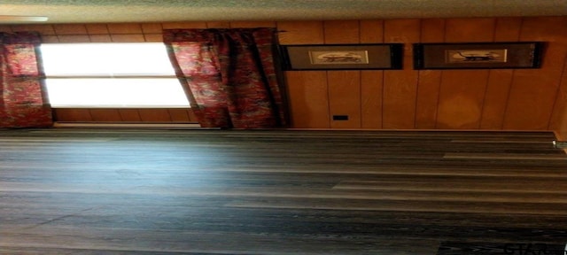 307 Lowry St, Arp, TX 75750 - empty room with plenty of natural light, wood finished floors, and a baseboard radiator