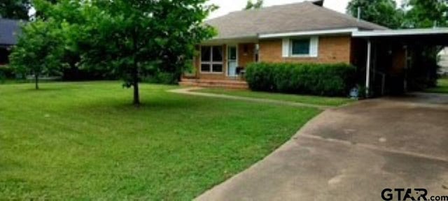 307 Lowry St, Arp, TX 75750 - ranch-style house with a front lawn, concrete driveway, and an attached carport