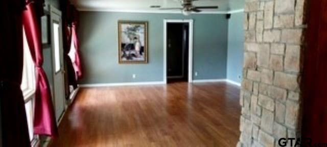 307 Lowry St, Arp, TX 75750 - empty room featuring wood finished floors, a ceiling fan, and baseboards