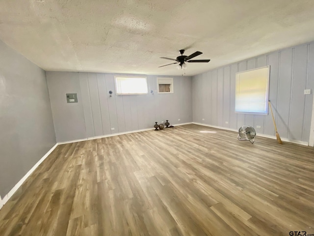 spare room featuring hardwood / wood-style flooring, ceiling fan, plenty of natural light, and a textured ceiling