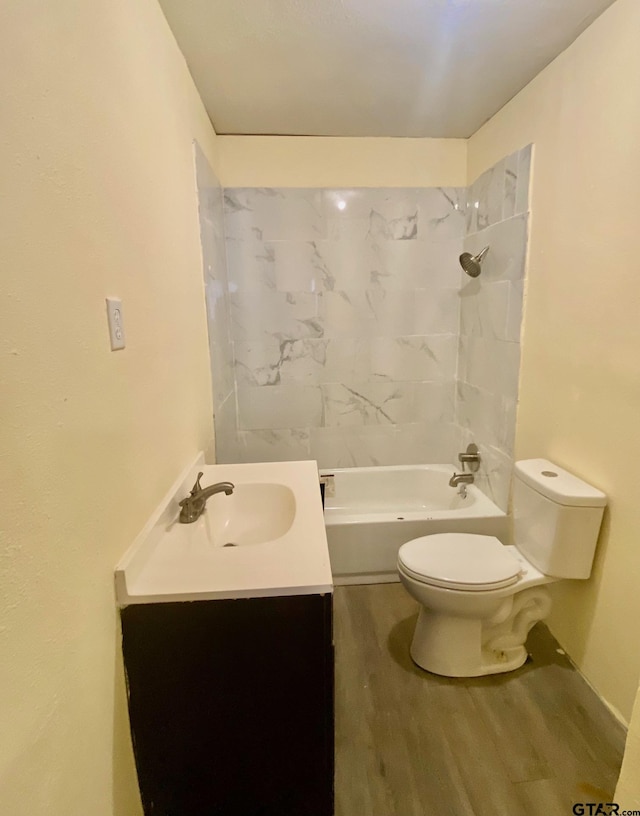 full bathroom with tiled shower / bath, vanity, toilet, and hardwood / wood-style floors