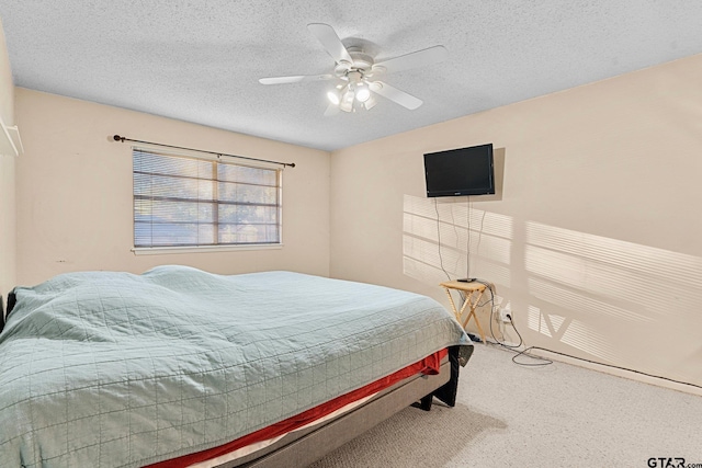 bedroom with a textured ceiling, carpet flooring, and a ceiling fan