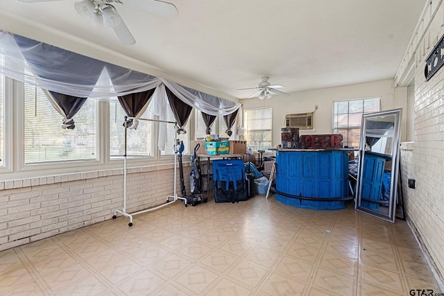 sunroom / solarium featuring an AC wall unit and ceiling fan