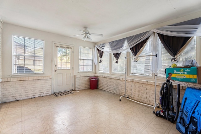 unfurnished sunroom featuring a ceiling fan