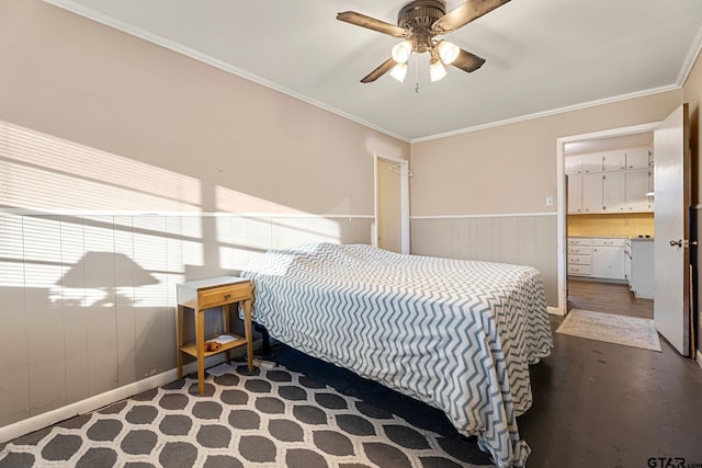 bedroom featuring ornamental molding, a ceiling fan, and wainscoting