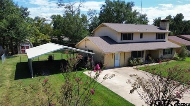 view of front of property featuring a front yard, concrete driveway, and a chimney