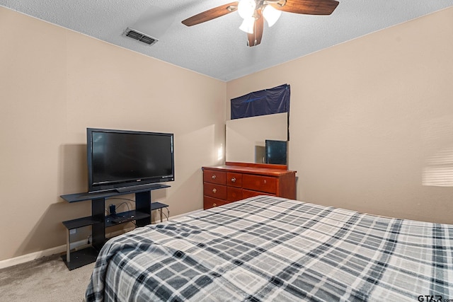 bedroom with light colored carpet, visible vents, a ceiling fan, a textured ceiling, and baseboards