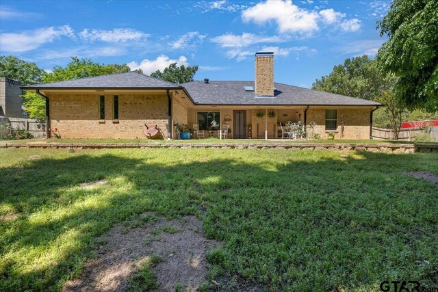 17599 Autumn Trl, Whitehouse, TX 75791 - rear view of house featuring a chimney, brick siding, fence, and a lawn