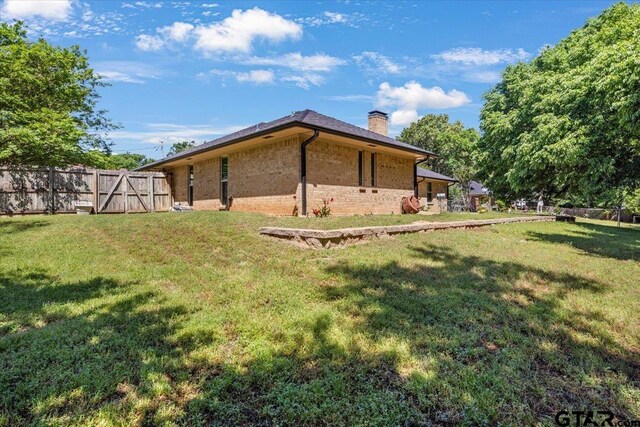 17599 Autumn Trl, Whitehouse, TX 75791 - view of home's exterior with fence, a chimney, brick siding, and a yard