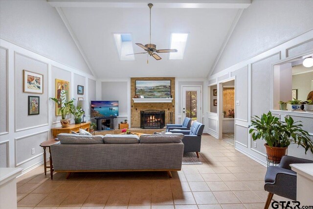 17599 Autumn Trl, Whitehouse, TX 75791 - living area featuring high vaulted ceiling, a decorative wall, a skylight, light tile patterned floors, and ceiling fan
