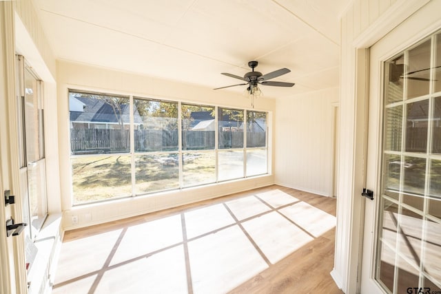 unfurnished sunroom featuring ceiling fan