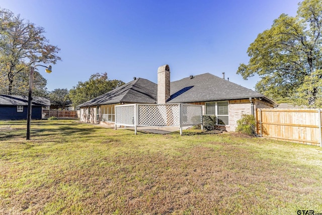 back of house featuring a lawn