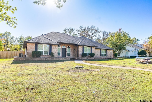 ranch-style home with a front yard and central AC unit