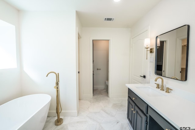 bathroom featuring a bathing tub, vanity, and toilet