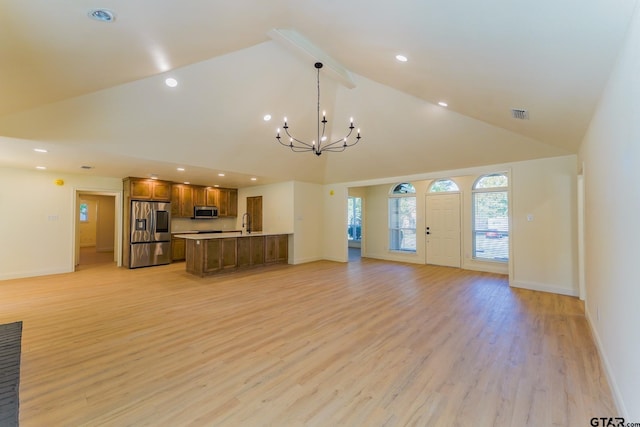 unfurnished living room featuring light hardwood / wood-style floors, sink, high vaulted ceiling, and a chandelier