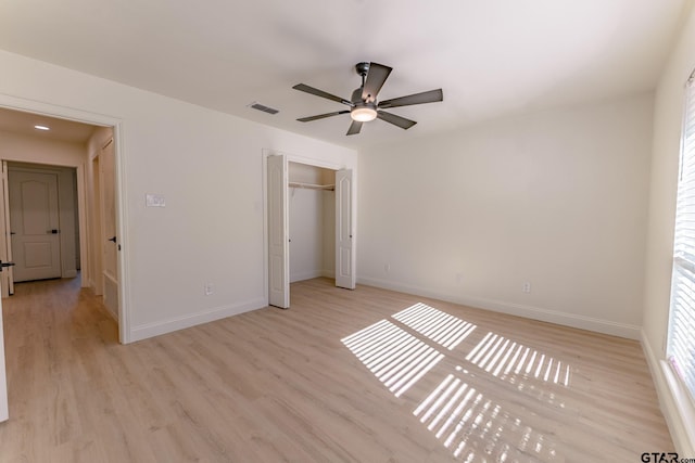 unfurnished bedroom featuring light hardwood / wood-style flooring, a closet, and ceiling fan