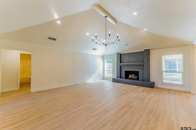 unfurnished living room featuring high vaulted ceiling, a brick fireplace, beam ceiling, a notable chandelier, and light hardwood / wood-style floors