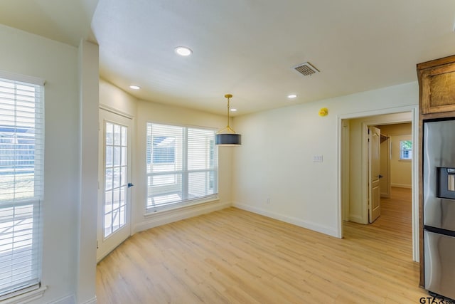 unfurnished dining area with a wealth of natural light and light hardwood / wood-style flooring