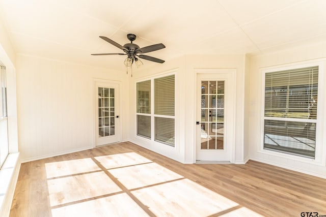 unfurnished sunroom with ceiling fan