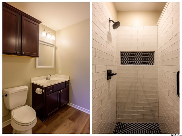 bathroom with hardwood / wood-style flooring, vanity, toilet, and a tile shower