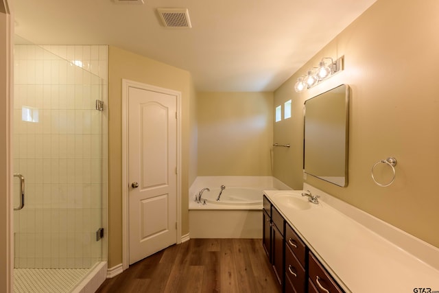 bathroom featuring hardwood / wood-style flooring, vanity, and shower with separate bathtub