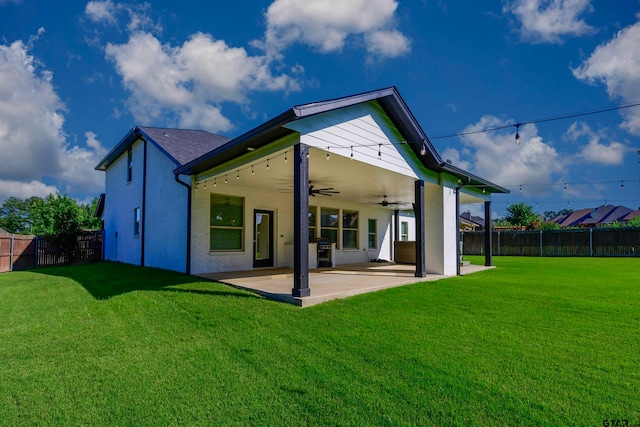 rear view of house featuring a lawn, ceiling fan, and a patio