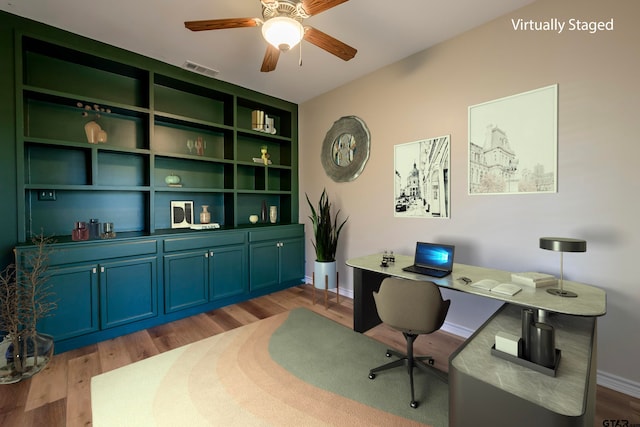 home office featuring ceiling fan, built in features, and light wood-type flooring