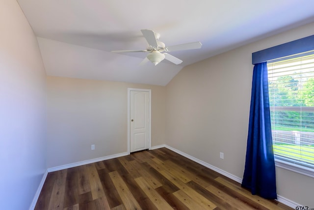 spare room featuring ceiling fan, dark wood-type flooring, and lofted ceiling