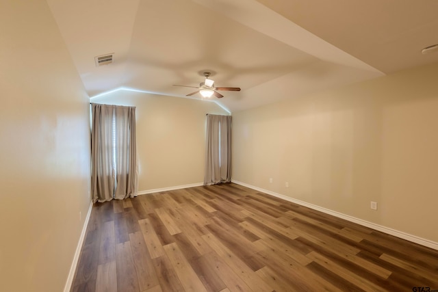 empty room with hardwood / wood-style flooring, vaulted ceiling, and ceiling fan