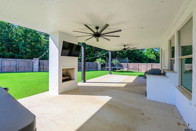 view of patio featuring an outdoor brick fireplace and ceiling fan