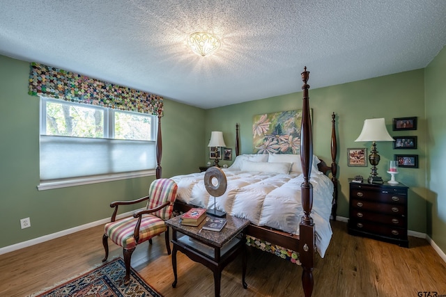 bedroom with wood-type flooring and a textured ceiling