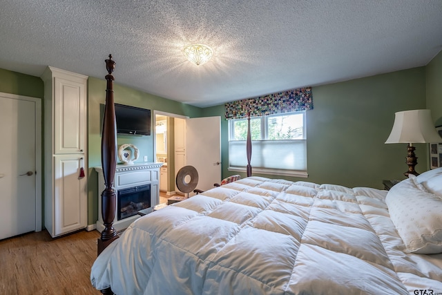 bedroom with light wood-type flooring and a textured ceiling