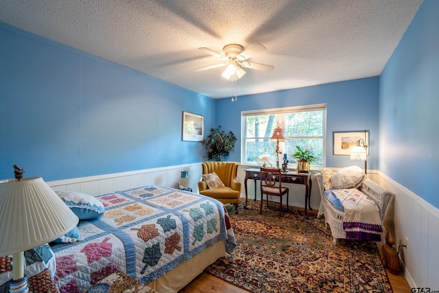 bedroom featuring ceiling fan, a textured ceiling, and hardwood / wood-style flooring