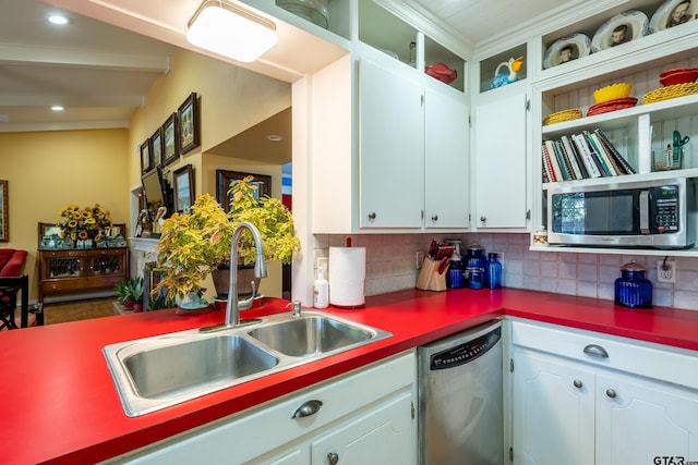 kitchen with decorative backsplash, white cabinetry, sink, and appliances with stainless steel finishes